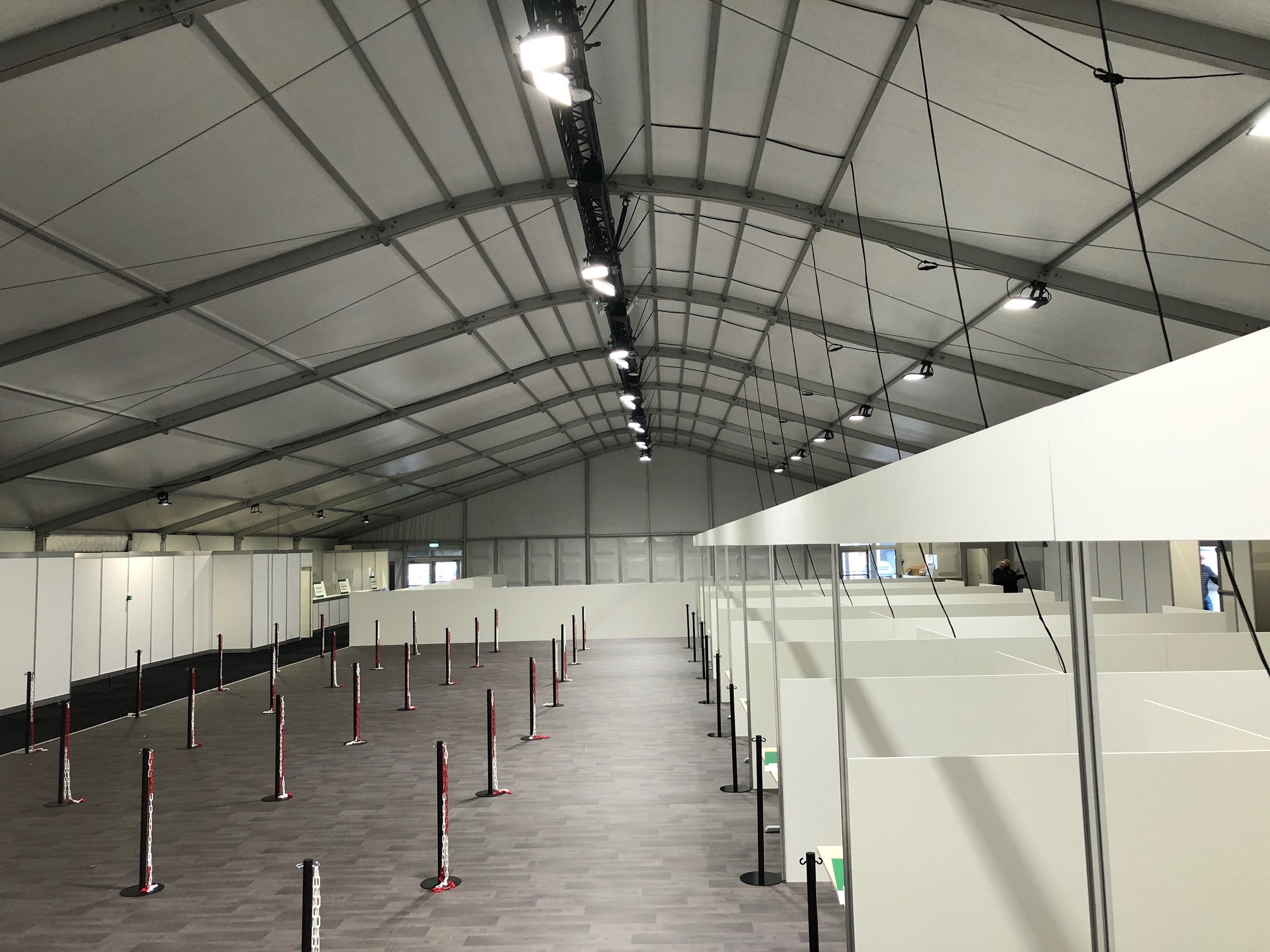 Interieur van de tijdelijke hal met looproutes en afgescheiden vaccinatieruimtes