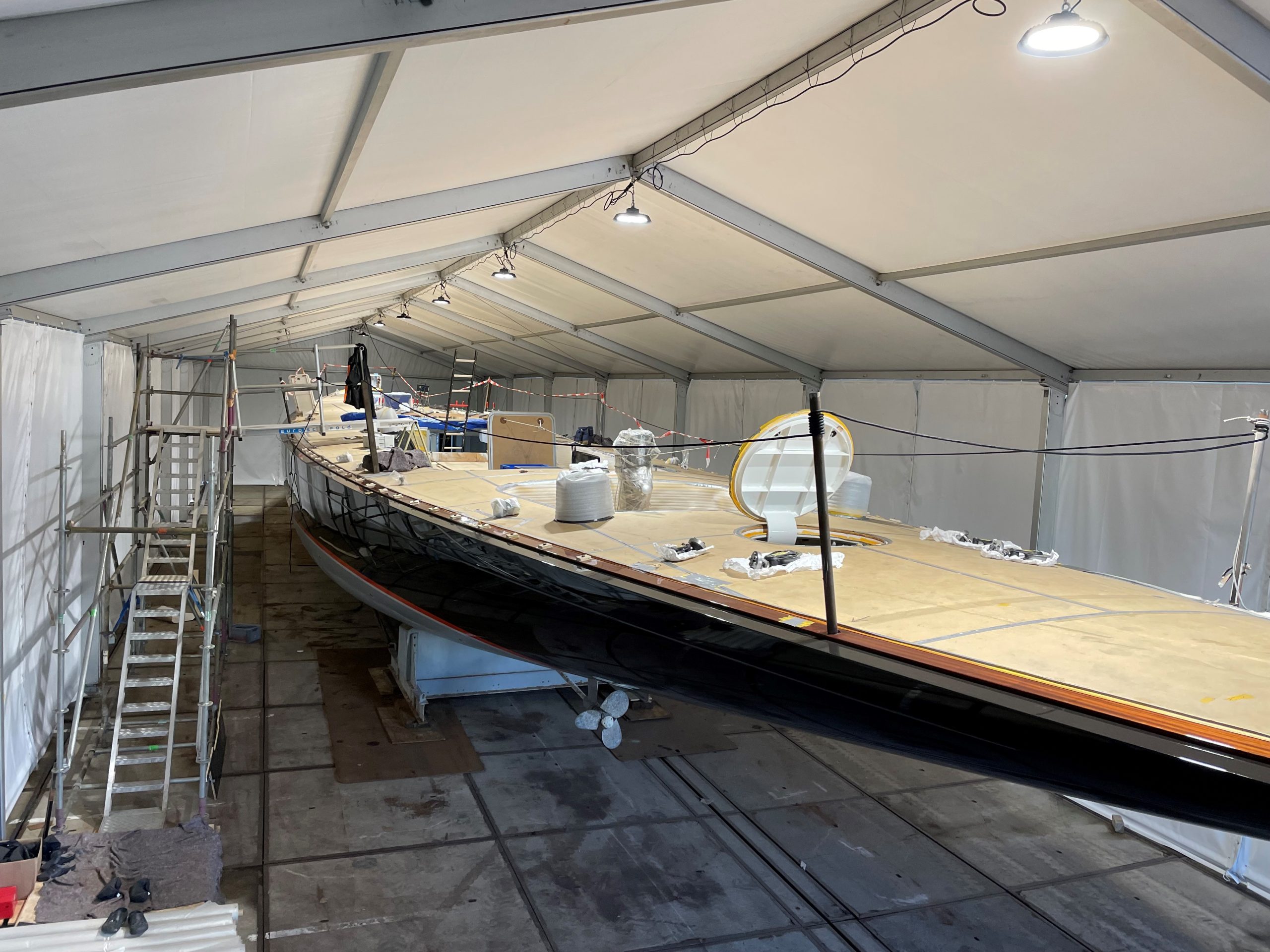 Werktent van 10 bij 40 meter met een zeiljacht in onderhoud, steigers en hallenverlichting
